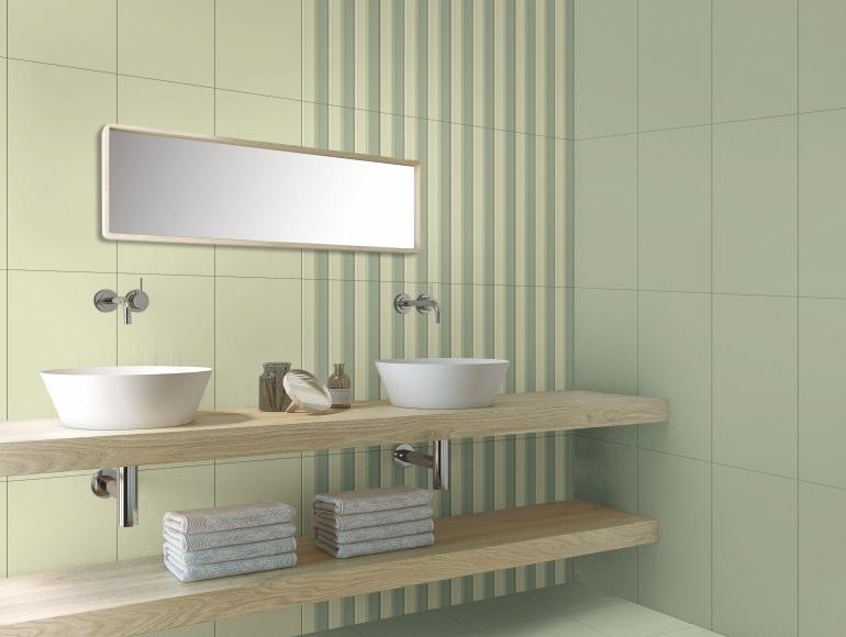 Minimalist green bathroom design with striped accent wall, wooden floating vanity, vessel sinks, and modern fixtures.